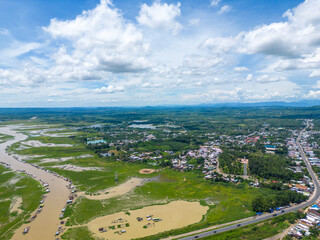 Aerial view of National Route 20 in Dong Nai province, group of floating house on La Nga river, Vietnam with hilly landscape and sparse population around the roads.