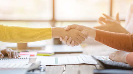 Portrait young Asian woman interviewer and interviewee shaking hands for a job interview .Business people handshake in modern office. Greeting deal concept