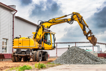 Powerful wheeled excavator at the construction site. Side view. Excavator with a wide bucket,...