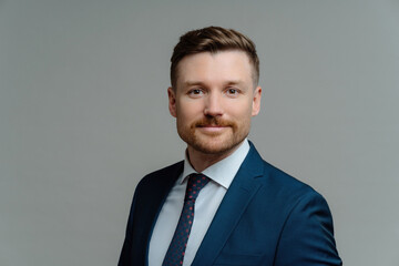 Serious bearded male manager in formal attire poses against grey background. Handsome employer prepared for business meeting. Job concept.
