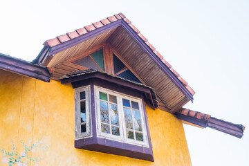 Wooden window of Yellow house with tree,vintage home concept.