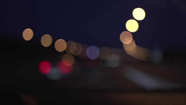 video from co-driver of car driving on freeway, car lights and street lights passing out of focus