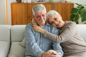 Senior adult mature couple hugging at home. Mid age old husband and wife embracing with tenderness love enjoying sweet bonding wellbeing. Grandmother grandfather together. Family moment love and care