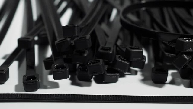 Plastic black ties on a white background. Plastic ties for cables.