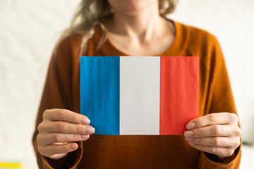 Small paper flag of France in hand