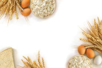 Cheese, barley and wheat and eggs on a white background with space for text. Top view, flat lay