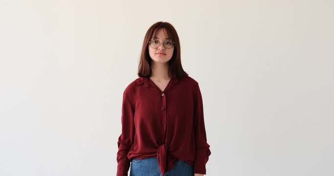A confident Caucasian teenage girl on white background. With unwavering determination, she showcases her assertiveness by raising her palm in a stop gesture, radiating confidence and strength.