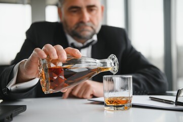 Old businessman drinking from stress.