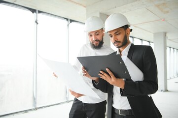 Construction concept of multiracial Engineer and Architect working at Construction Site with blue print