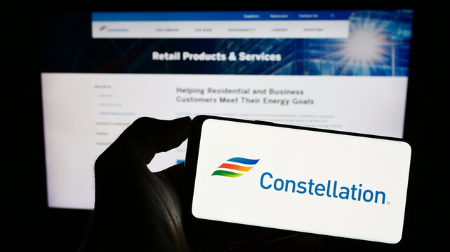 Stuttgart, Germany - 06-25-2023: Person holding smartphone with logo of US company Constellation Energy Corporation on screen in front of website. Focus on phone display.