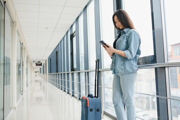 tourism, holiday, vacation, childhood and transportation concept - smiling little girl with travel bag over airport background