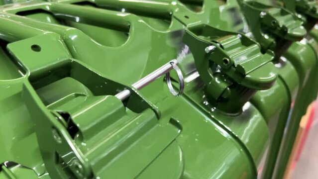 New green metal 20-litre gas cans or jerrycans stand in a row in a car and motoring shop or auto store