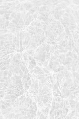 Fototapeta premium White water with ripples on the surface. Defocus blurred transparent white colored clear calm water surface texture with splashes and bubbles. Water waves with shining pattern texture background.