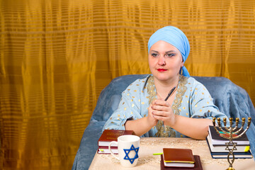 A Jewish woman in a headdress kisui rosh a teacher of tradition gives a lecture to women gesticulating with her hands.