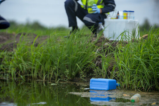 Environmental researchers investigate the condition of canal water for toxic spills, river waste water sampling, Asian researchers collect water samples in farmland for research and development.