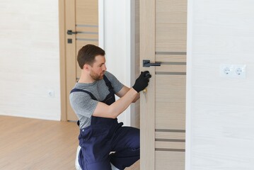 Young man fixing the door in house