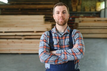 Young man carpenter at the wooden warehouse. Copy space for text