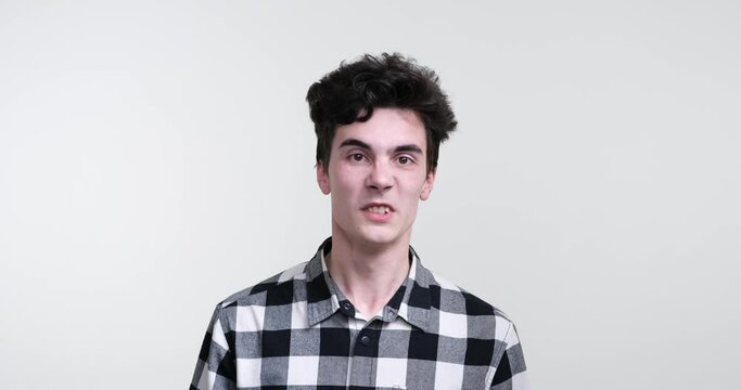 Against a stark white background, a curly-haired man of Caucasian descent stands with an air of aggression and fury. His piercing gaze reveal a seething anger that simmers just beneath the surface.