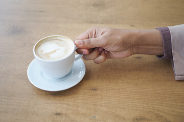 women holding a coffee cup on table 