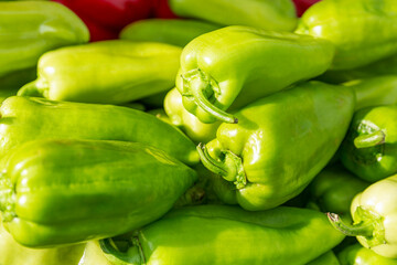 Lots of sweet green peppers on the counter in the market. Health, vitamins and organic products. Close-up.