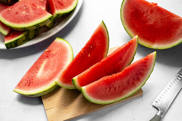 Fresh red juicy watermelon slices on cutting board.