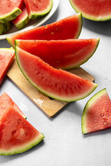 Fresh red juicy watermelon slices on cutting board.