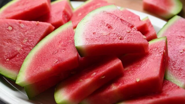 Fresh red juicy watermelon slices in a plate, top view. Summer fresh fruit snack.