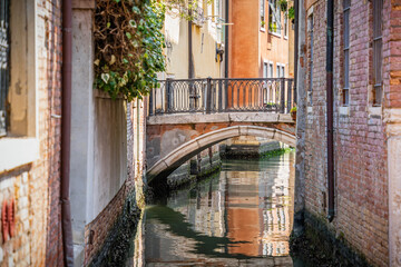 Fototapeta na wymiar Idyllic scene from Venice, Italy with stone bridge over the narrow water canals