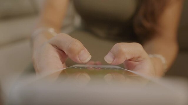close up on fingers typing. hands of brazilian woman texting and typing on the mobile smart phone at home. 