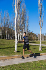 Young attractive athlete sportsman runner jogging in the morning in public park. Copy space