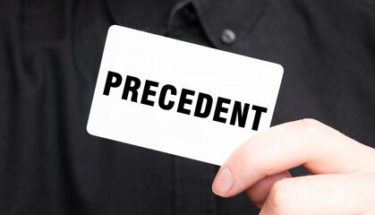 Businessman holding a card with text PRECEDENT, business concept