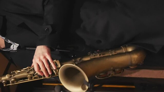 A saxophonist in a suit playing music close up