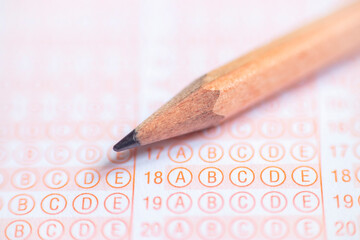 School Students hands taking exams, writing examination holding pencil on optical form of standardized test with answers sheet doing final exam in classroom. Education assessment Concept. Stock photo 