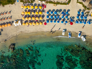 Italy, July 2023: aerial view from the drone of a crystalline Caribbean sea with bathers and beach umbrellas at Grotticelle locality near Capo Vaticano, Tropea, Calabria