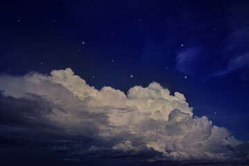 Black dark blue night sky with clouds and stars. A storm is coming, thunder, rain. Lightning flashes. Glow. Dramatic.