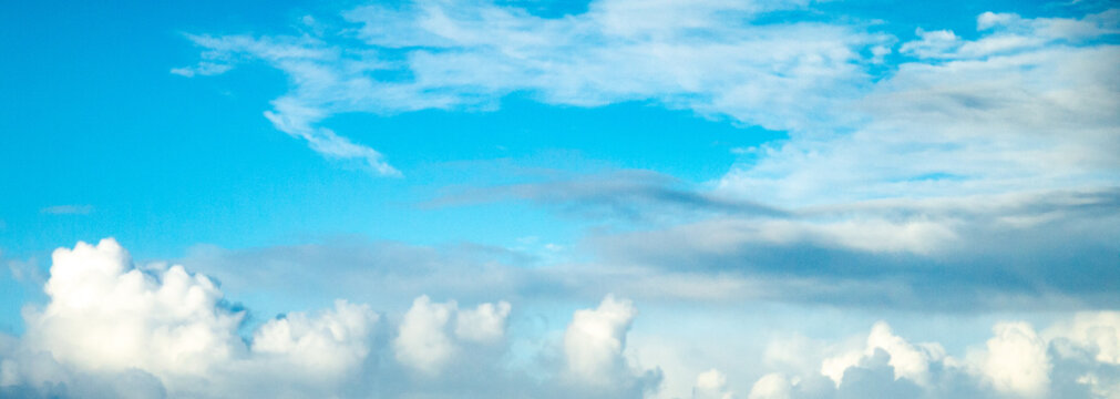 Aqua blue sky over ocean with building clouds shot at 74 mm focal length