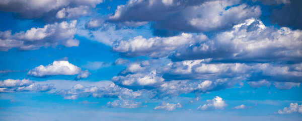 Blue sky with puffy white clouds shot at 90 mm focal length
