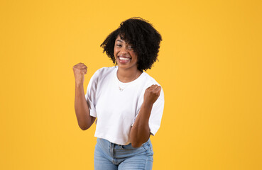 Laughing millennial black lady in casual making victory and success sign