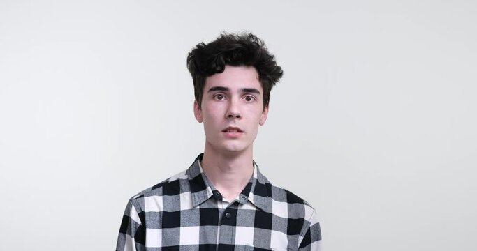 A curly-haired Caucasian man on white background, he stands, his body trembling uncontrollably, his eyes wide with terror. Feel the tension as his quivering movements convey the depths of his fright.