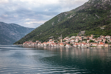 Fototapeta na wymiar Landscape Exposure done from a cruise ship at sunset, showing the sea entrance to Kotor bay and its beautiful coastal landscapes and small villages , on a sunshiny day.