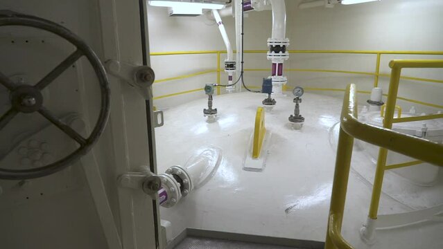 Tank inside room. Upper part of a large vertical tank.