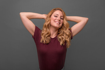 Fototapeta premium Smiling girl on a grey background, crossed her arms over her chest.