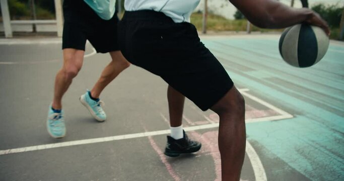 Close-up shot of a Black man in a white t-shirt bypassing his opponent in a light green t-shirt and scoring a brilliant goal into the basketball goal on the outside basketball card