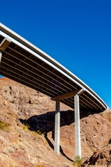 Solitude in the Desert: Solo Driving on Dark Black Road, Amidst Red Rocks and Majestic Mountains