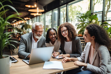 Obraz premium A multigenerational business team in a collaborative workspace, using digital devices and technology to enhance productivity Generative AI