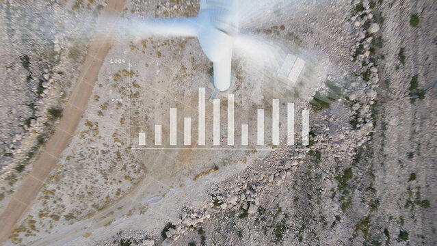Top View Of A Wind Turbine With Digital Graphics Of Statistical Graph Being Analyzed By Mechanical Engineer At Work