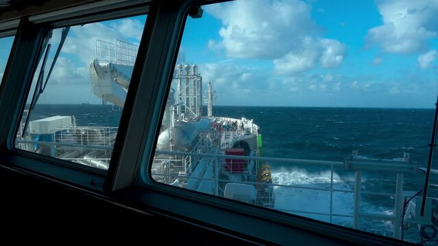 Ship in storm. View from bridge. Splashes from waves at bow of tanker. Strong pitching.
