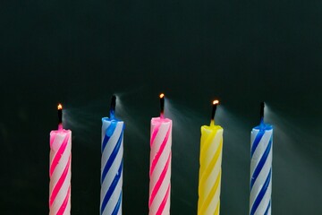 Vibrant Celebrations: Close-Up of Colorful Birthday Candle Flames Against a Black Background, Illuminated in Captivating 4K Resolution