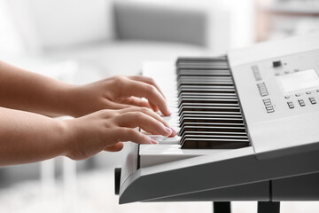 Fototapeta na wymiar Woman playing modern synthesizer, closeup