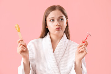 Thoughtful young woman choosing between shaving and sugaring on pink background - obrazy, fototapety, plakaty